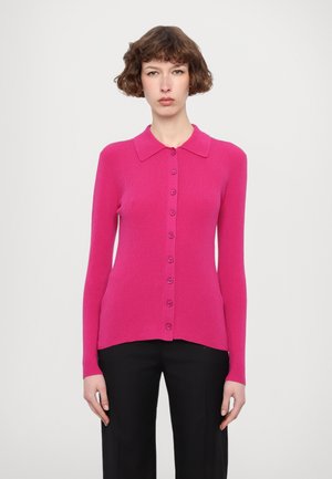Cardigan ajustat, cu mânecă lungă, dintr-un material ribatit de un roz vibrant, având un guler și șapte butoane la închidere pe față.