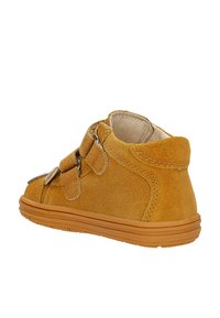 Stivale alla caviglia giallo in suede con due chiusure a strap, punta arrotondata e suola in gomma texturizzata. Presenta un collo imbottito e dettagli di cucitura.