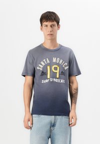 Tengerész kékszínű, kerek nyakú, rövid ujjú póló, sárga és fehér "Santa Monica 19 Surf Syndicate" grafikai nyomattal.