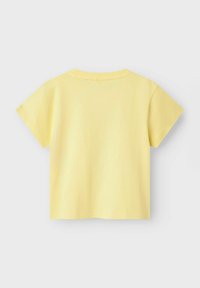 Żółta bawełniana koszulka z krótkim rękawem, okrągłym dekoltem i prostym krojem. Widoczne są szwy, a projekt jest prosty.