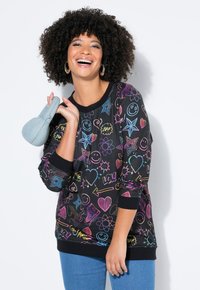 Felpa nera con pattern di scarabocchi multicolori, che includono faccine sorridenti, cuori e stelle. Maniche lunghe con polsini a coste neri.