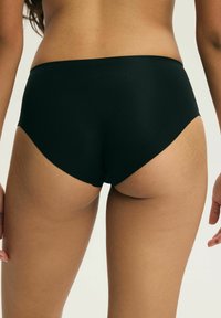 Czarne majtki od kostiumu kąpielowego z wysokim stanem, o prążkowanej fakturze i gładkim wykończeniu, z zachowawczym krojem i bez widocznych elementów metalowych.