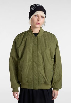 Veste bomber matelassée vert olive avec col et poignets côtelés, présentant des motifs de couture subtils et des fermetures à boutons-pression.