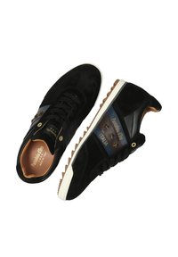 Černé semišové tenisky s hnědými a modrými akcentními pruhy, bílé podrážky a hvězdné detaily. Disponují polstrovaným jazykem a kontrastními tkaničkami.