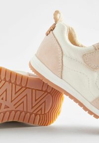 Sneaker mit einem Obermaterial aus beigem und cremefarbenem Stoff mit strukturierter Oberfläche, Wildlederakzenten und einer Gummisohle mit Zickzackprofil.