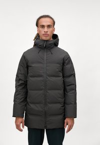 Sort polstret jakke med høj krave, lynlås og justerbare snore. Har et kviltet design og sidelommer. Mat tekstur.