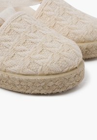 Espadrilky z přírodních vláken s pleteným svrškem ve světlém béžovém odstínu a silnou juteovou podrážkou, která má texturovaný vzor.