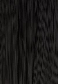 Schwarzer Stoff mit dichten, vertikalen Falten, die ein strukturiertes, gefaltetes Aussehen erzeugen und subtile Lichtreflexionen auf der Oberfläche zeigen.