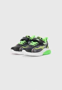 Baskets de sport noires et vertes au design épuré, arborant un graphique de voiture et des accents verts vifs. La semelle est blanche avec des détails verts.