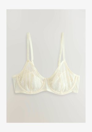 Creme blonder BH med gennemsigtige mesh-paneler, bøjle støtte, justerbare stropper, bølget kant og blomsterlacer detaljer på kopperne.