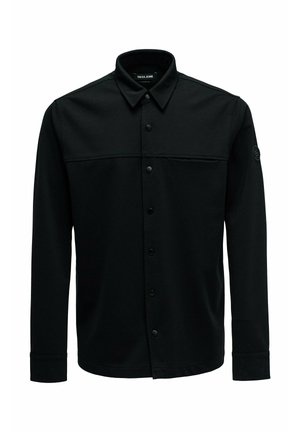 Zwarte overhemdjas gemaakt van gladde stof, met een knoopsluiting aan de voorkant, een puntige kraag, lange mouwen en een opvallend borstnaaddetail.