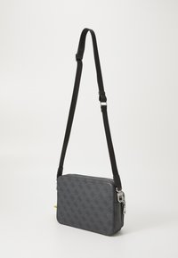 Bolso crossbody gris con un diseño estampado, cierre de cremallera, correa negra ajustable y herrajes plateados. Forma rectangular con una textura suave.