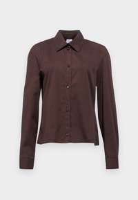 Camisa de botones marrón oscuro con mangas largas, collar puntiagudo y botones negros. Elaborada con un tejido suave y de patrón liso.