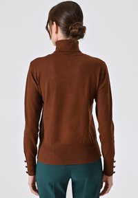 Brauner, taillierter Rollkragenpullover mit glatter Textur, gerippten Akzenten am Saum und den Manschetten, ausgestattet mit dekorativen Knöpfen an den Ärmeln.