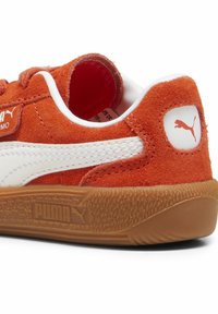 Narančaste nubuk tenisice s bijelim detaljima, gumeni potplat te istaknuti PUMA logotip na peti. Imaju prošivene detalje i podstavljeni ovratnik.