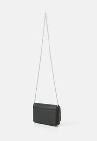 Bolso bandolera de cuero negro con superficie texturizada, forma rectangular y correa de cadena plateada. Cuenta con un diseño de solapa para el cierre.