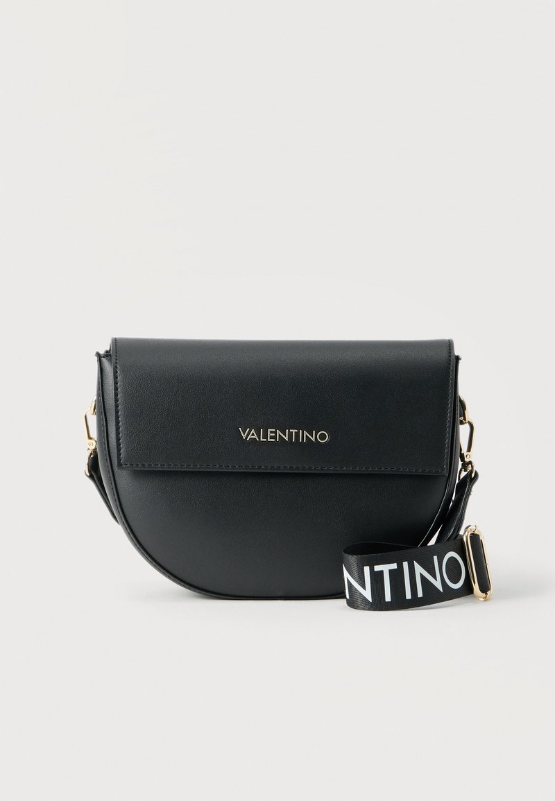 Μαύρη τσάντα crossbody Valentino σε σχήμα ημισελήνου με καπάκι, εξαρτήματα σε χρυσό τόνο και ρυθμιζόμενο μαύρο λουρί με λευκή επωνυμία Valentino.