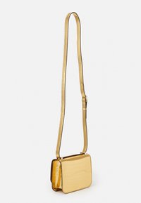 Gul krokodillembossed crossbody taske med rektangulær form, slank rem og slank finish, der har karakteristiske strukturerede overflader og kanter.