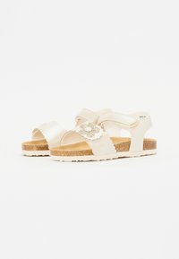 Witte, open-toe sandalen met een kurkzool; voorzien van geschulpte banden en een bloemenaccent met rhinestones. Verstelbare band voor de juiste pasvorm.
