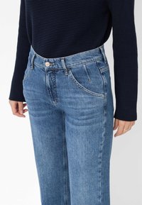 Hoge taille blauwe spijkerbroek met een lichte wassing, recht model, vijf zakken en een zilveren knoopsluiting.