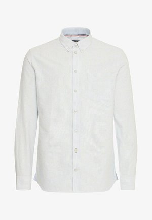 Gaiši zils krekls ar baltām un gaiši zilām svītrām, garām piedurknēm, ar pogājamu apkakli un priekšējo kabatu. Izgatavots no kokvilnas materiāla.