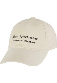 Beige bomull baseball cap med svart brodert tekst "Aim’r Sportswear Sweden New Zealand 2013" på forsiden. Bøyd visirdetalj.