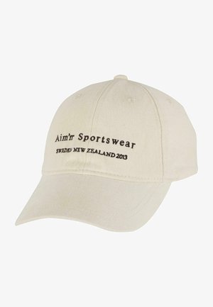 Bežinis medvilninis beisbolo kepuraitė, ant priekio su juodu siuvinėtu tekstu "Aim’r Sportswear Sweden New Zealand 2013". Išlenktas zono detalė.