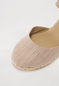 Brune stribede espadrille med lukket tå, kanvasoverdel og jutesål. Har en tekstureret inderside og et lavskåret design.