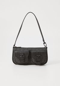 Black handbag featuring two front pockets with buckle accents, a textured fabric body, and a slim adjustable strap. Zipper closure on top.