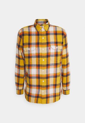 Camisa de cuadros en amarillo, naranja, blanco y azul marino con botones, mangas largas, cuello y dos bolsillos en el pecho, mostrada sobre un fondo blanco.