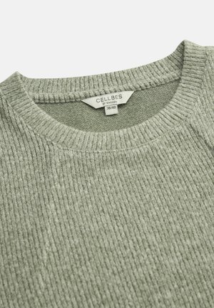Lichtgrijze geribbelde trui met een ronde hals. Heeft een gestructureerde stof en een maatlabel "CELLBES of SWEDEN 38/40" bij de kraag.