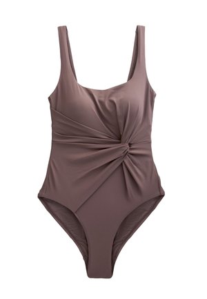 Detail tmavohnedého odevu so skrúteným uzlom vytvárajúcim zoskupené záhyby látky v oblasti pásu.