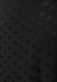 Schwarzer Stoff mit einem erhabenen Kettenmuster, das eine glatte Textur und eine einheitliche Farbe aufweist. Keine weiteren Details vorhanden.