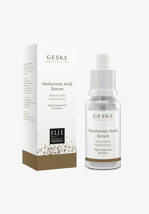 Siero all'acido ialuronico in una bottiglia di vetro trasparente con dettagli argentati. Scatola con sfondo bianco, fondo oro e dettagli del logo in nero.