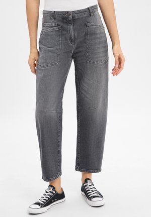 Graue Denim-Hosen mit lockerer Passform, ausgestattet mit zwei vorderen Taschen, geraden Beinen und einem klassischen Knopfverschluss, kombiniert mit schwarzen Sneakers.