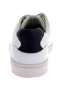 Baskets en cuir blanc avec une semelle en caoutchouc texturé, accent au talon bleu marine, lacets plats et intérieur rembourré.