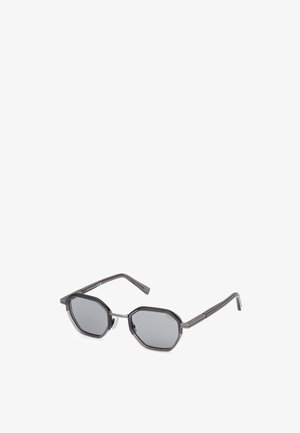 Sunglasses with octagonal gray lenses, dark gray plastic frame, thin temples, and silver accents near the hinges.