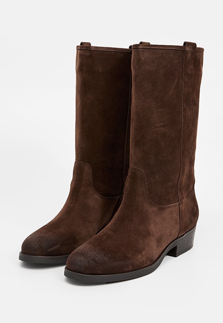 Stivali alla caviglia in suede marrone con finitura liscia, gambo dritto, punta arrotondata e tacco basso. Design minimalista senza hardware visibile.