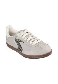 Beige sneaker with white laces, dark brown sole, and black patterned logo on the side, angled to show outer and top views.