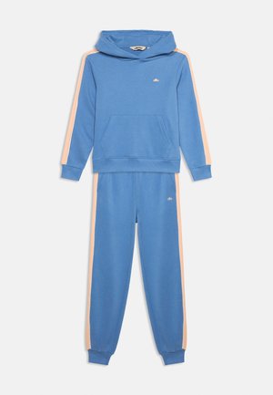 Μπλε φούτερ με κουκούλα και ταιριαστά παντελόνια φόρμας με ρηχές ρίγες ροδάκινου στα πλάγια και μικρό λογότυπο στο στήθος και στο μηρό.