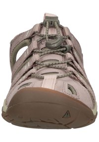 Light pink outdoor shoe with grey accents, mesh cutouts, elastic laces, and a rubber sole featuring a triangular logo detail.