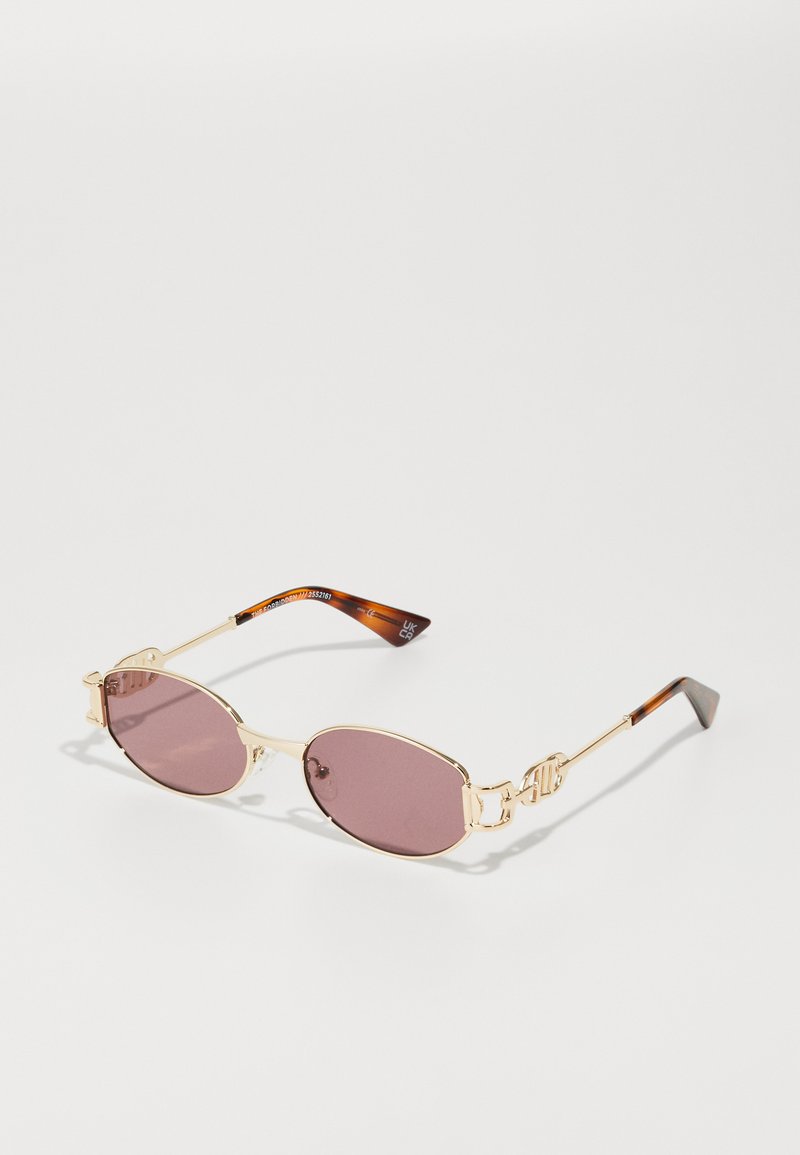 Gafas de sol de metal dorado con lentes ovalados rosas. Puntas de las patillas con patrón de carey. Diseño minimalista con un marco estrecho y acentos de logo.
