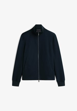 Mørkeblå jakke med fuld lynlås, ståkrave, lange ærmer og to sidelommer, lagt fladt på en hvid baggrund.