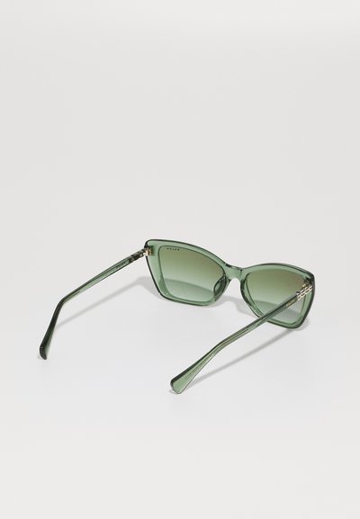 Occhiali da sole cat-eye verde con lenti oscurate, montatura trasparente verde e aste eleganti con dettagli sottili. Design classico con un tocco moderno.