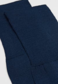 Marineblaue Socken mit geripptem Muster, die ein glattes Strickdesign aufweisen. Der Stoff ist weich und dehnbar, ideal für den täglichen Gebrauch.