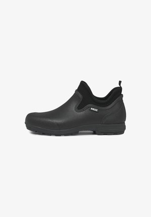 Black waterproof slip-on shoe with a smooth, matte finish, textured sides, and a rugged outsole for traction. Features pull tab for easy wear.