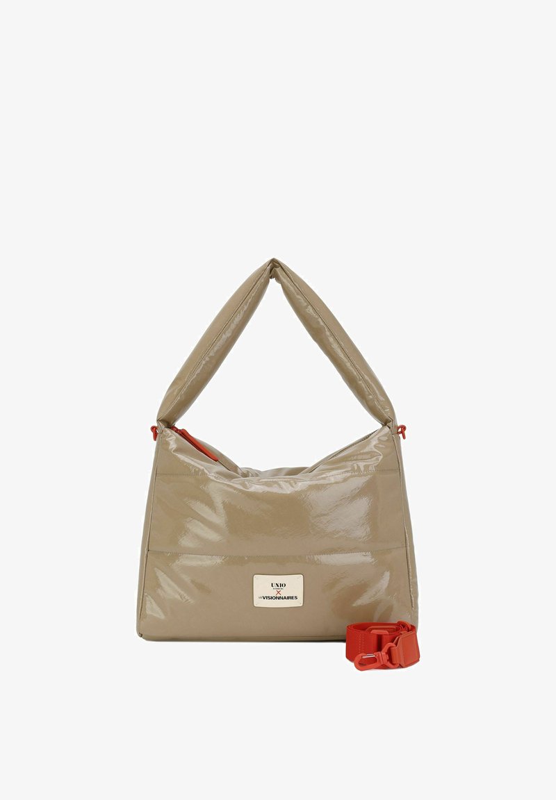 Bolso de mano de piel sintética beige con un asa triangular plegada y detalles en cremallera naranja. Incluye una correa de hombro naranja desmontable.