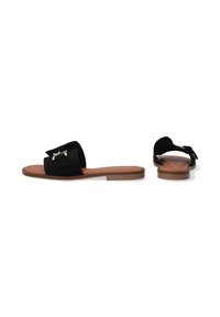 Zwarte suède schuifsandalen hebben een brede band met een metalen accent, een vlakke bruine zool en een eenvoudig, open achterontwerp voor gemakkelijke instap.
