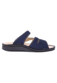 Navy blue slide sandals made of soft suede, featuring wide cutouts, stitched accents, and a stable black rubber sole.
