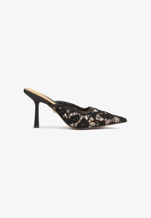 Mule en dentelle noire avec un bout pointu et un petit talon aiguille. Doté d'un dessus transparent avec des motifs floraux et d'un bord noir lisse.